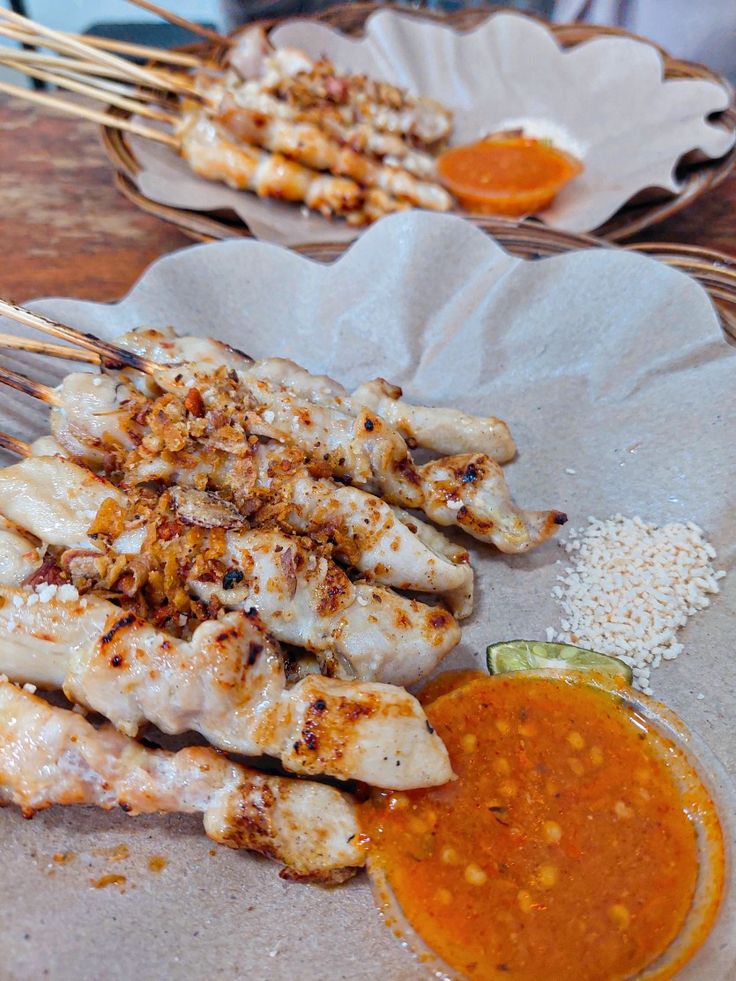 Dua porsi sate taichan dengan daging berwarna putih kecoklatan lengkap dengan cocolan sambal dan bubuk kaldu jamur