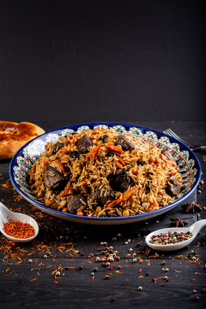 Nasi berwarna cokelat dengan topping potongan daging dan wortel